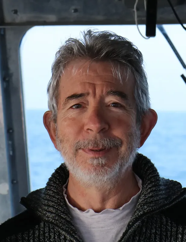 Portrait d'un homme aux cheveux gris souriant sur un bateau