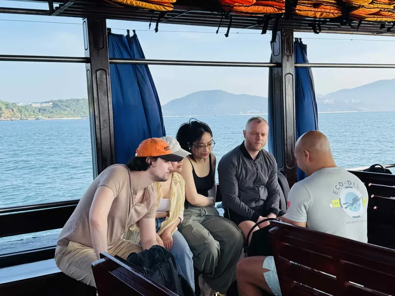 Quatre personnes assises sur un bateau en direction d'un site de plongée