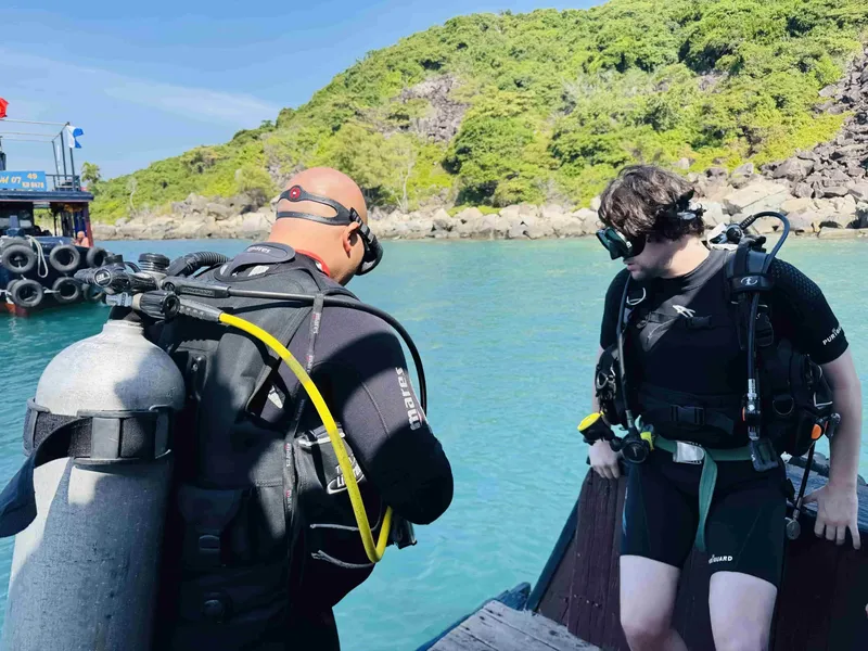 Deux plongeurs s'équipent sur un ponton avant une immersion