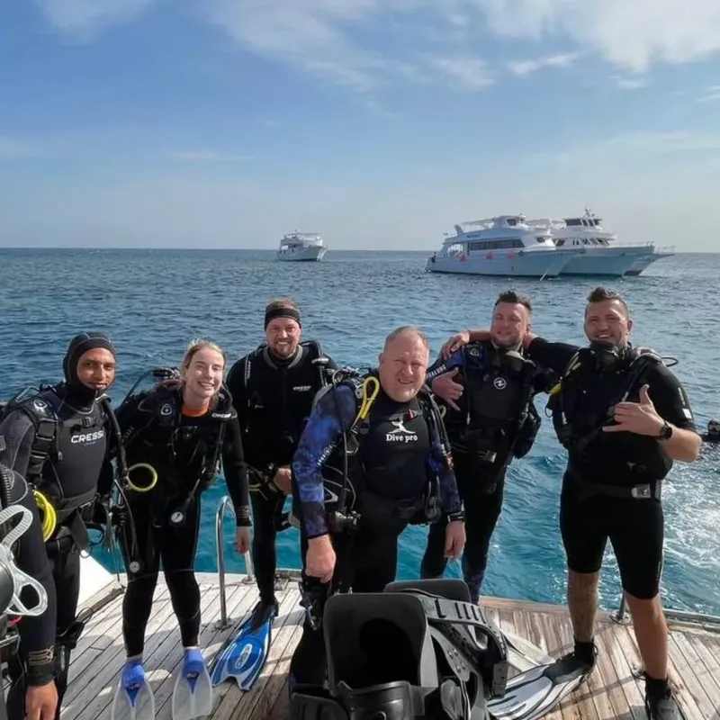 Groupe de plongeurs souriants sur le pont d'un bateau en mer
