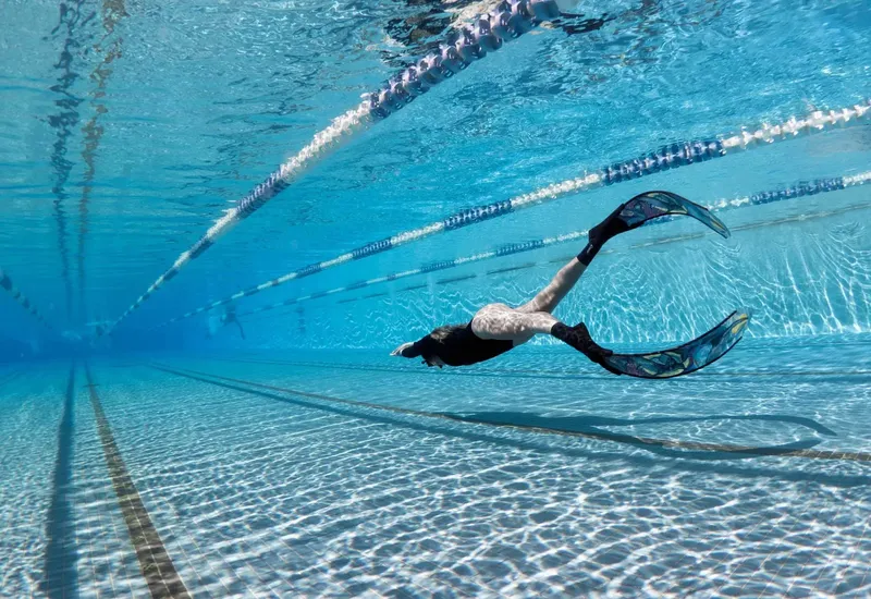 Nageur en apnée dans une piscine, vue sous-marine, lignes de flottaison