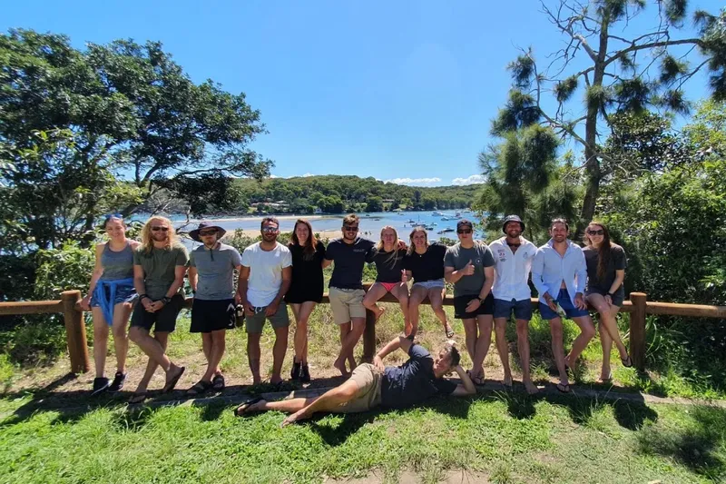 Groupe de personnes souriantes posant devant une vue sur la mer