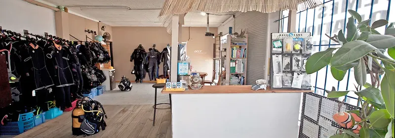 Intérieur d'un centre de plongée avec équipement, comptoir et personnes