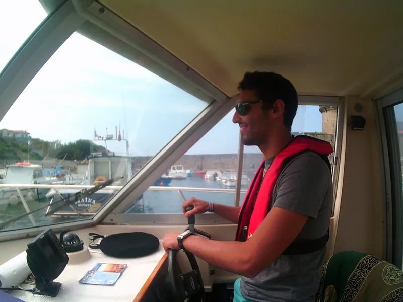 Homme conduisant un bateau de plaisance dans un port ensoleillé