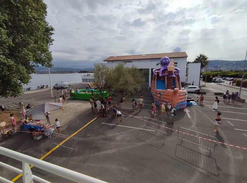 Parking avec structures gonflables, personnes et bâtiment du centre de plongée