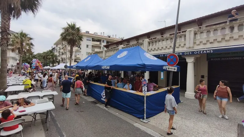Stand bleu sur une promenade avec des gens et des bâtiments