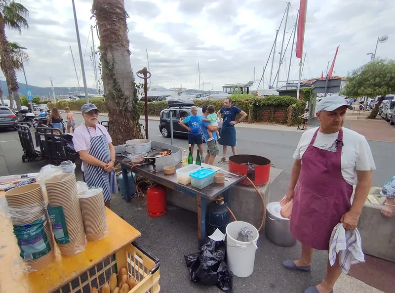 Personnes préparant et servant de la nourriture près d'un port de plaisance