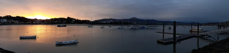 Port de plaisance au coucher du soleil avec bateaux amarrés et ponton