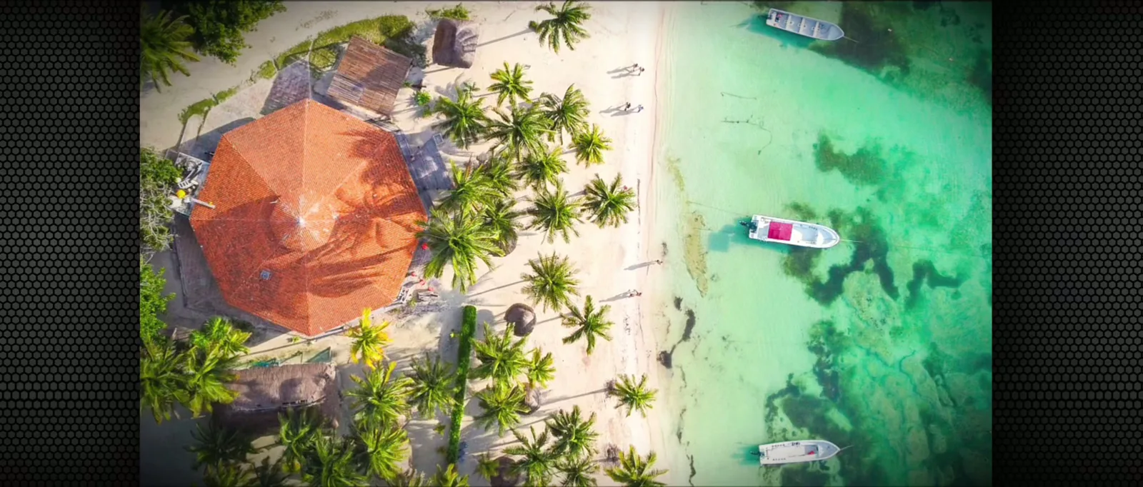 Vue aérienne d'une plage tropicale avec des bateaux et bâtiments
