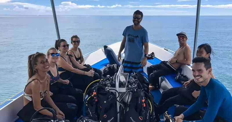 Groupe de plongeurs souriants à bord d'un bateau de plongée en mer
