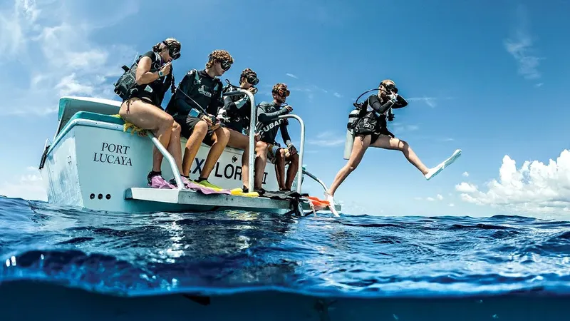 Plongeurs sur un bateau bleu, préparation à un saut dans l'eau