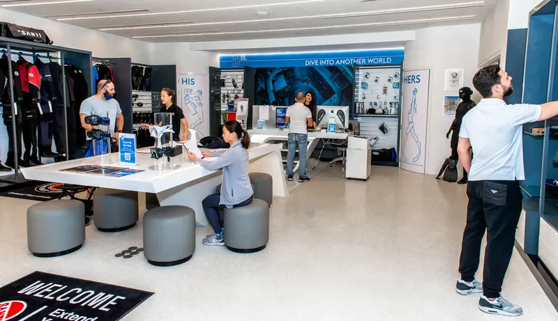 Intérieur d'un centre de plongée avec des clients et du matériel