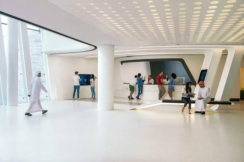 Intérieur moderne d'un centre avec des personnes devant un comptoir d'accueil