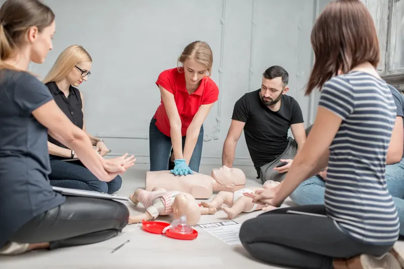 Groupe de personnes suivant une formation de premiers secours avec mannequins