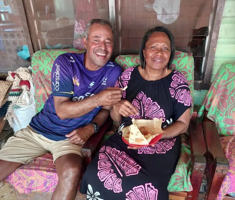 Deux personnes souriantes posent ensemble dans un intérieur coloré