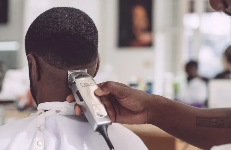 Un homme se fait couper les cheveux par un coiffeur dans un salon