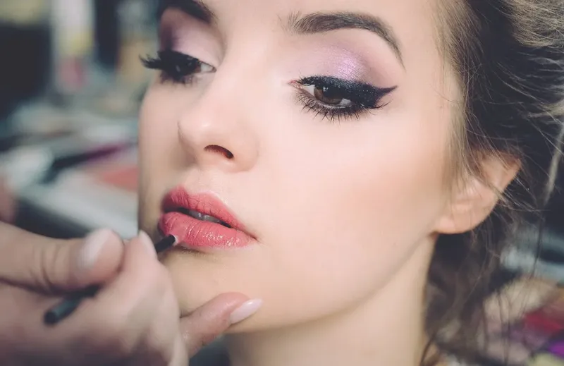Portrait d'une femme maquillée, regard intense, lèvres rouges, pose professionnelle