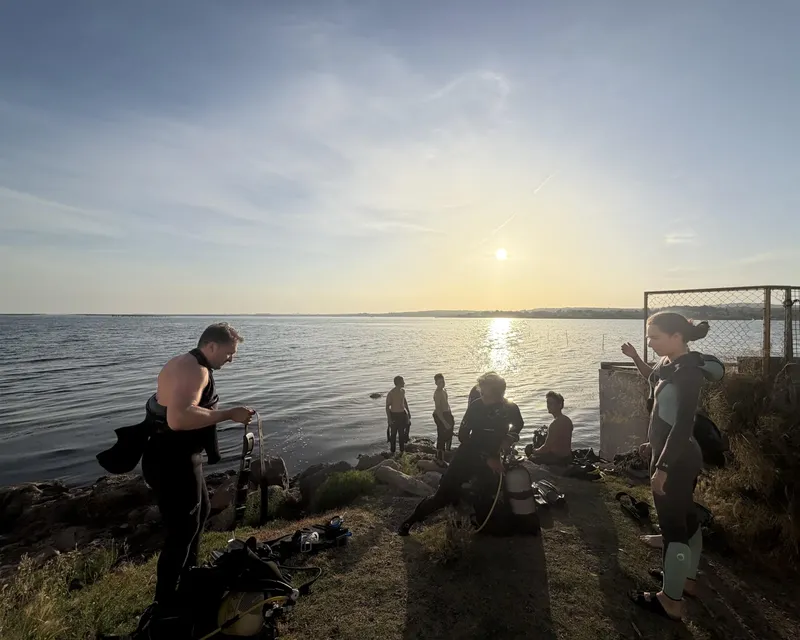 Groupe de plongeurs préparant leur matériel au bord de l'eau