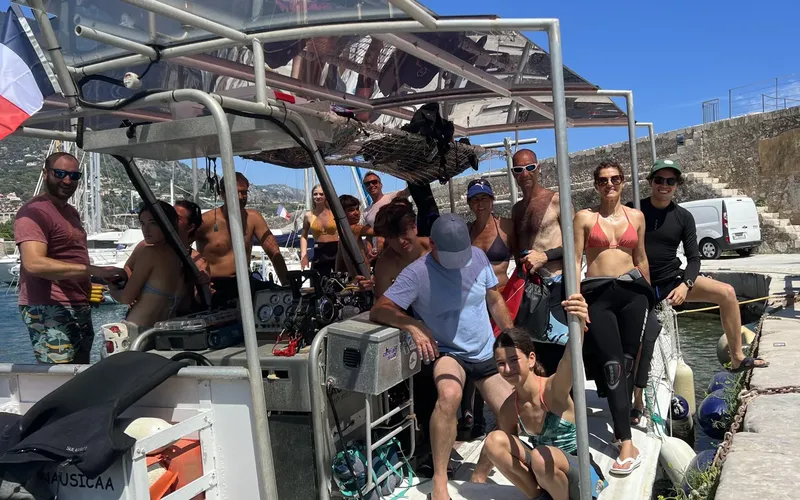 Groupe de plongeurs souriants à bord d'un bateau de plongée ensoleillé