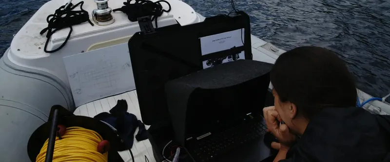 Personne travaillant sur un ordinateur portable à bord d'un bateau pneumatique