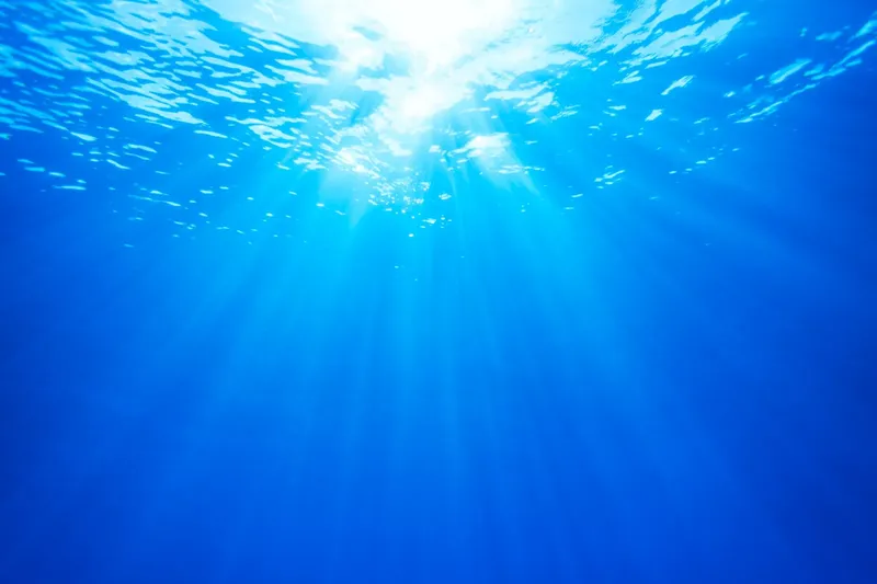 Vue sous-marine avec rayons de soleil perçant la surface de l'eau