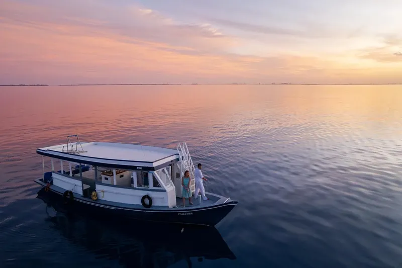 Bateau de plongée en mer au coucher du soleil avec deux personnes