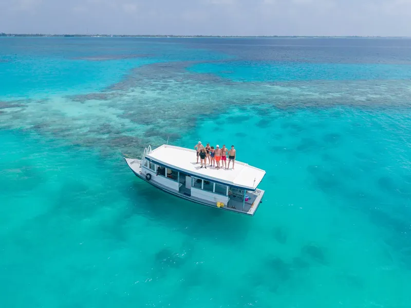 Vue aérienne d'un bateau avec des personnes à bord sur mer turquoise