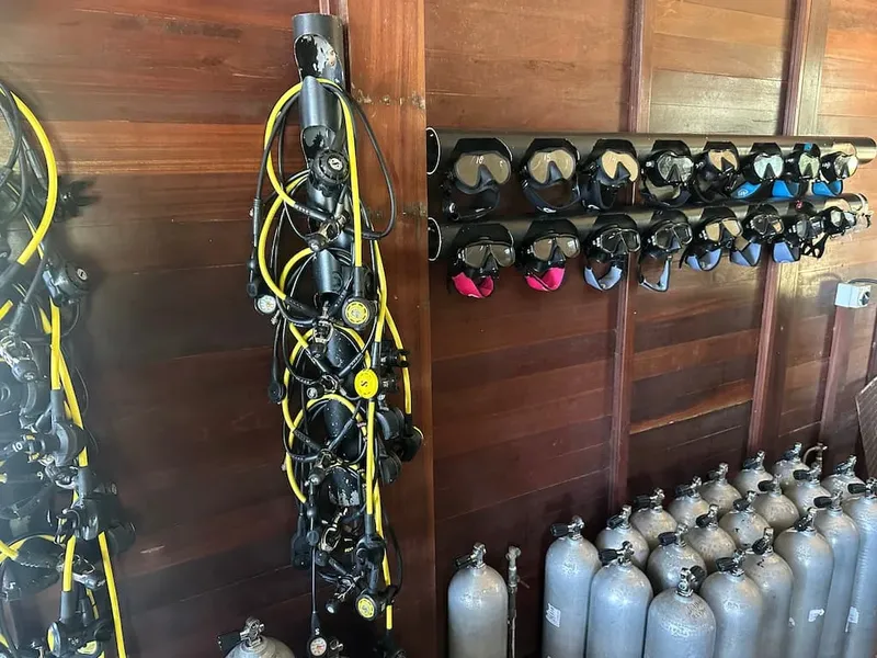 Equipement de plongée complet suspendu et rangé dans un local sombre