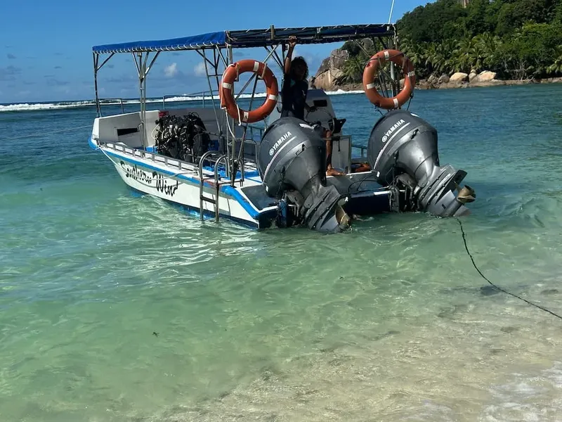 Bateau de plongée échoué sur une plage tropicale avec des passagers