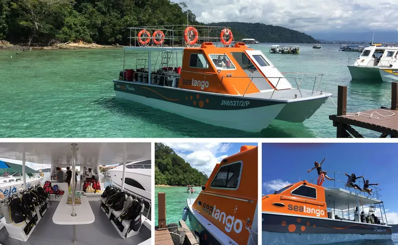 Bateau de plongée orange et bleu amarré à un ponton en bois