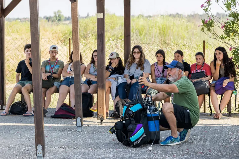 Groupe de jeunes écoute un instructeur avec du matériel de plongée