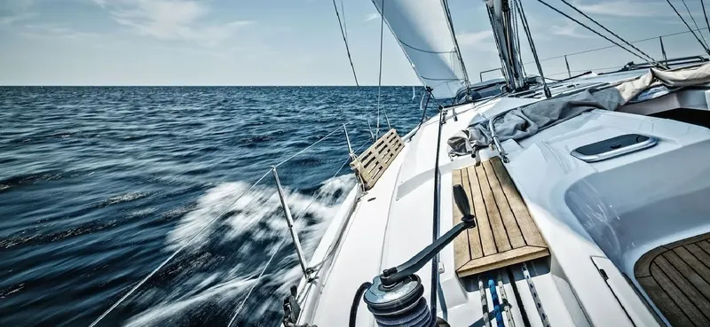 Voilier blanc naviguant sur une mer bleue avec des vagues