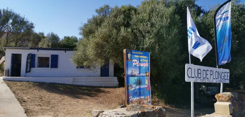 Façade d'un club de plongée avec panneau d'information et drapeaux flottants