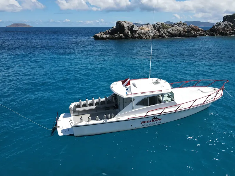 Bateau de plongée blanc et bleu sur une mer turquoise calme