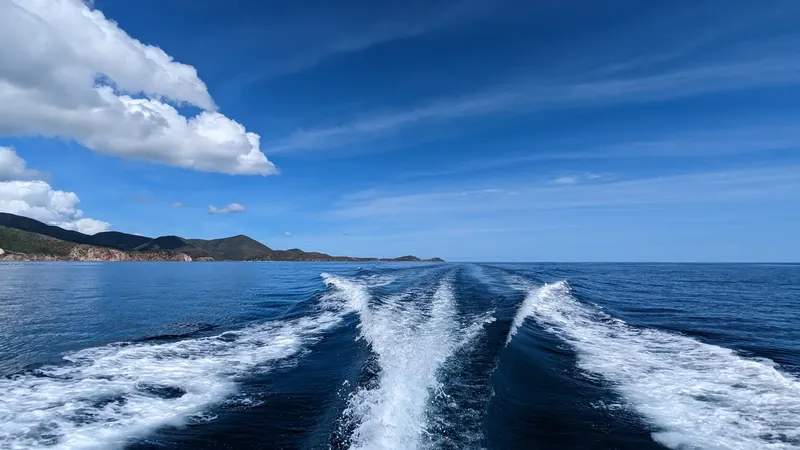 Vue arrière d'un bateau naviguant sur une mer bleue et calme