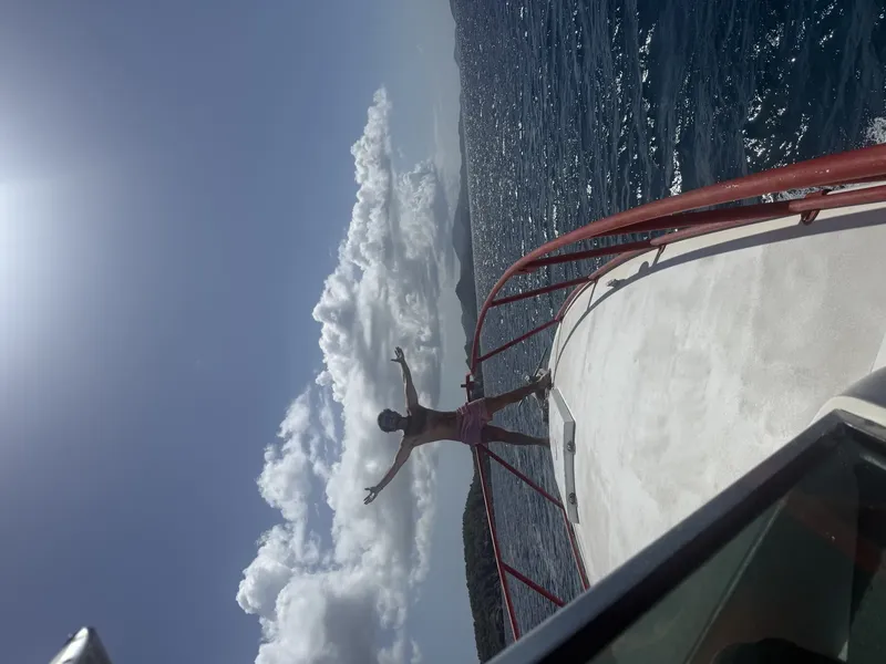 Homme se penchant au-dessus d'un bateau en mer ciel bleu nuages
