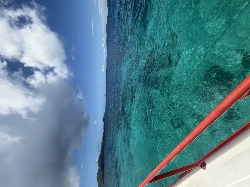 Vue depuis un bateau sur l'eau turquoise et le ciel nuageux