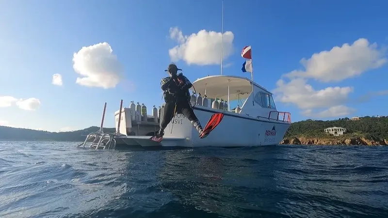 Plongeur s'apprête à entrer dans l'eau depuis un bateau de plongée