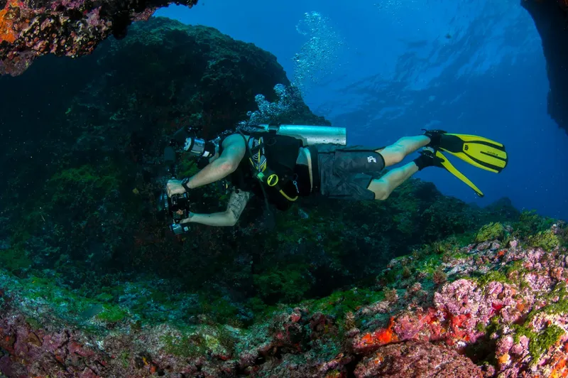 Plongeur explore une grotte sous-marine avec équipement complet et lumière
