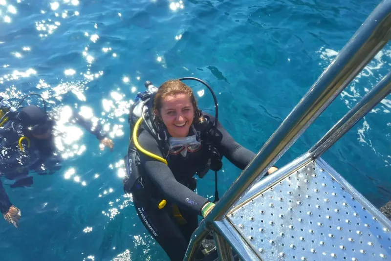 Plongeuse souriante remonte à bord d'un bateau après une immersion