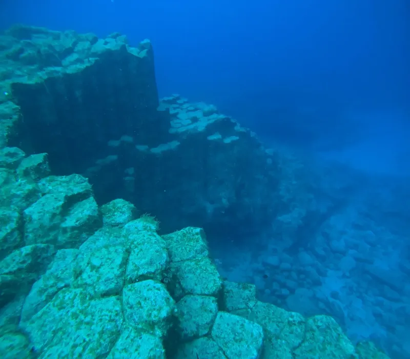Fond marin rocheux avec des blocs de pierre et du sable clair