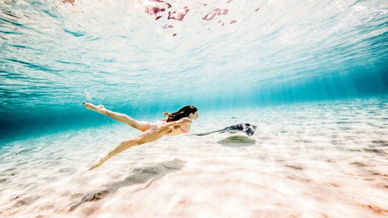 Femme nageant sous l'eau dans un environnement marin clair et ensoleillé