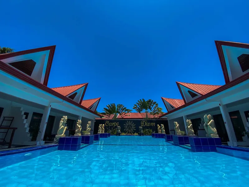 Piscine d'un centre de plongée avec inscription Carpe Diem et statues