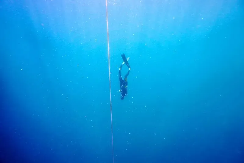 Apnée en profondeur, un plongeur descend le long d'un câble vertical