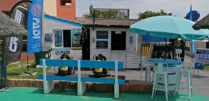 Façade d'un centre de plongée avec matériel et espace détente extérieur