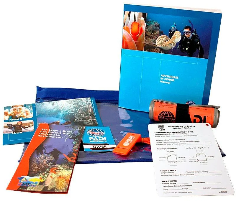 Manuels de plongée PADI, matériel et documents de formation sur fond blanc