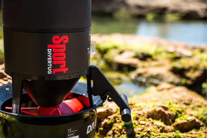 Scooter des mers noir et rouge avec des rochers et de l'eau