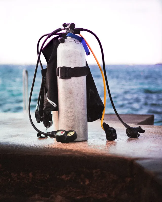 Equipement de plongée complet posé sur un quai en béton face à la mer
