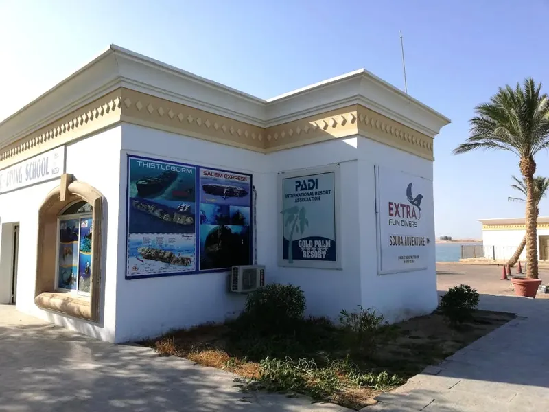 Façade d'un centre de plongée avec affiches de sites et logos