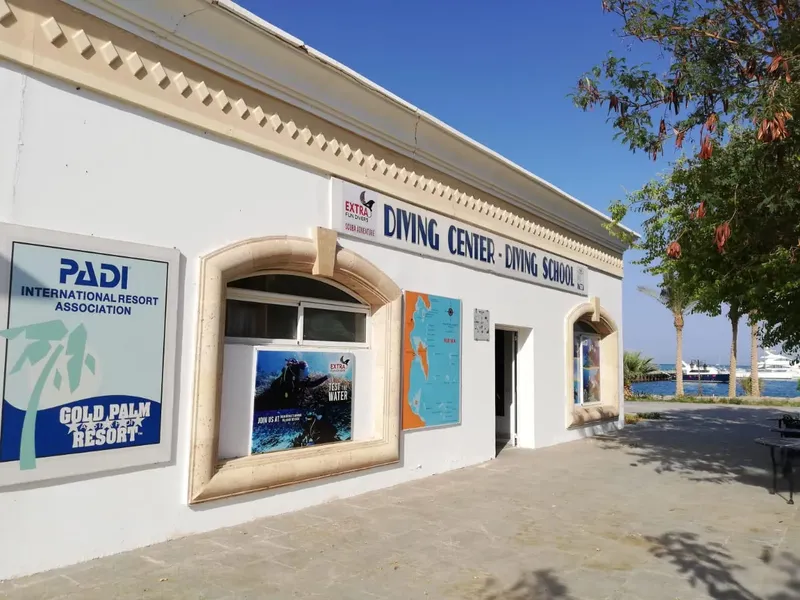 Façade d'un centre de plongée avec logos PADI et Gold Palm Resort